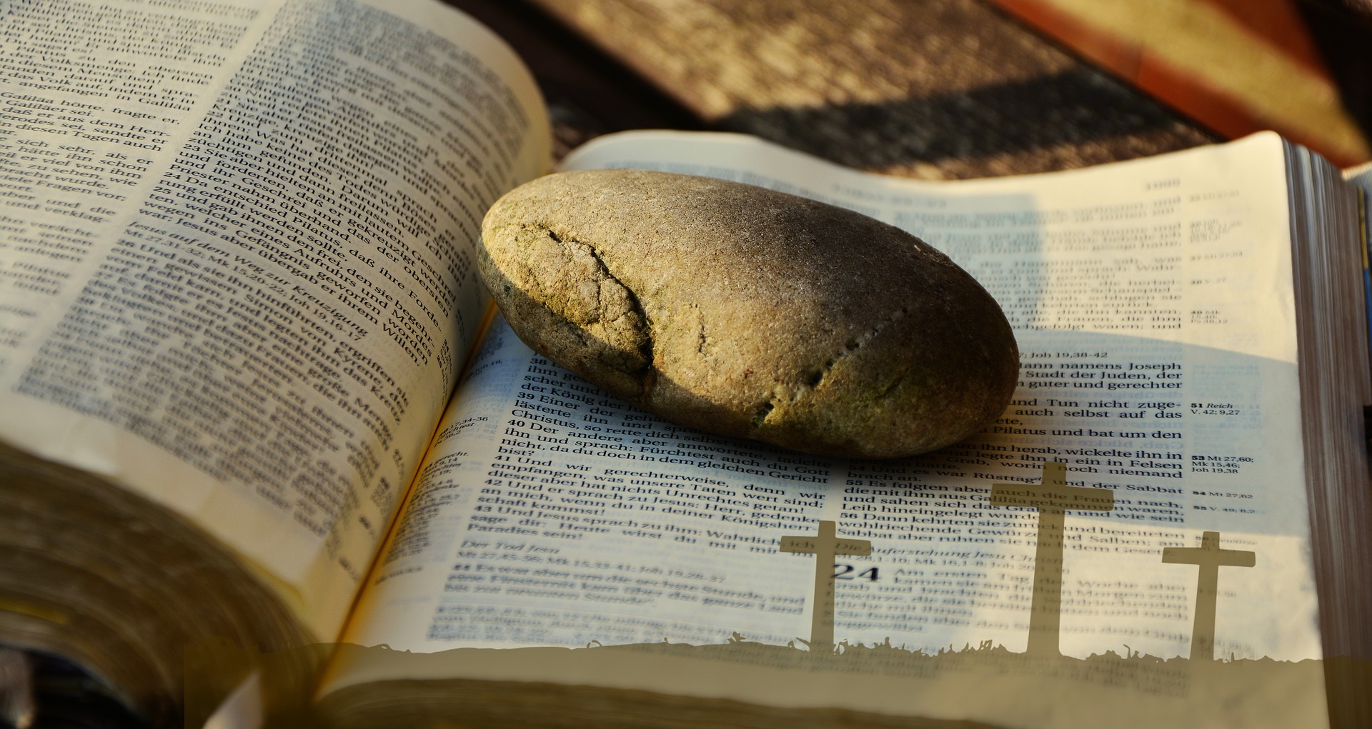 Aufgeschlagene Bibel mit Brot und einem Kreuz